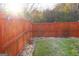 Fenced backyard featuring a well-maintained lawn and a rock border, providing a private outdoor space at 7625 Bowhead Ct, Fairburn, GA 30213