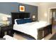 Stylish bedroom with dark wood furniture, a large bed, and two matching lamps and neutral carpet floors at 7625 Bowhead Ct, Fairburn, GA 30213