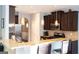 Modern kitchen with stainless steel appliances, granite countertops, and dark wood cabinetry with pendant lights at 7625 Bowhead Ct, Fairburn, GA 30213