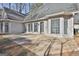 Back patio with large concrete area and adjacent sunroom, offering an excellent space for outdoor enjoyment at 114 Oak Ridge Dr, Sharpsburg, GA 30277
