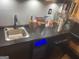 Close-up of wet bar features, sink, cocktail accessories, and illuminated floating shelf at 3223 Thornecreek Dr, Douglasville, GA 30135