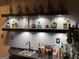 Finished basement bar with floating shelves stocked with bar accessories and liquor at 3223 Thornecreek Dr, Douglasville, GA 30135