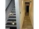 Hallway featuring black and white stairs with lights and an adjacent hallway with wood-look flooring at 3223 Thornecreek Dr, Douglasville, GA 30135