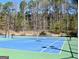 Community tennis court with lights and surrounding trees at 3223 Thornecreek Dr, Douglasville, GA 30135
