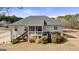 Back exterior showcasing a wooden deck and stairs leading to the yard in a serene setting at 391 Hickory Lake Dr, Acworth, GA 30101