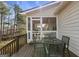 Outdoor deck area featuring metal table and chairs, screened-in porch, and wooded view at 391 Hickory Lake Dr, Acworth, GA 30101