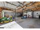 Spacious garage featuring a lawn mower, concrete floors and exposed ceiling at 391 Hickory Lake Dr, Acworth, GA 30101