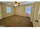 Bright bedroom featuring carpet flooring, two windows for ample light, and a ceiling fan at 2228 Headland Dr, East Point, GA 30344