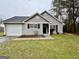 Traditional single-story home featuring neutral siding, an attached garage, and a quaint front yard at 890 Old Rocky Rd, Atlanta, GA 30349