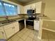 Kitchen with stainless steel appliances, tiled floors, white cabinets, granite countertops, and a breakfast bar at 890 Old Rocky Rd, Atlanta, GA 30349
