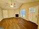Bright living room with a vaulted ceiling, fireplace, wood-look flooring, and natural light from large windows at 890 Old Rocky Rd, Atlanta, GA 30349