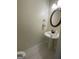 Clean powder room with a pedestal sink, decorative mirror, and neutral color palette at 2618 Hooch Ct, Duluth, GA 30097