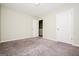 View of the spacious bedroom with neutral carpeting and a window letting in natural light at 415 Arthurs Ln, Covington, GA 30016