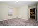 View of the spacious bedroom with neutral carpeting and a window letting in natural light at 415 Arthurs Ln, Covington, GA 30016