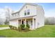Inviting two-story home with a covered porch, lush green lawn, and convenient two-car garage at 415 Arthurs Ln, Covington, GA 30016