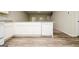Clean kitchen featuring white cabinets, countertops, and modern appliances with wood look flooring at 415 Arthurs Ln, Covington, GA 30016