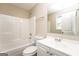 Bright bathroom featuring a shower-tub combo, toilet, and vanity with a large mirror at 430 Birch Se Ln, Conyers, GA 30094