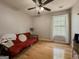 Bedroom with wood floors, ceiling fan, and a large window letting in natural light at 815 Lake Stone Lea Dr, Oxford, GA 30054