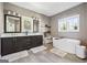 This bathroom features a double vanity with a soaking tub beneath a large window at 1685 Tabor Dr, Marietta, GA 30062