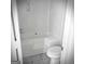 Clean, all-white bathroom featuring a bathtub, tile floors, and updated fixtures at 8053 Woodlake Dr, Riverdale, GA 30274