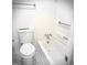 Bright bathroom featuring a white toilet and bathtub with chrome fixtures and towel bars at 8053 Woodlake Dr, Riverdale, GA 30274