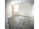 Sunlit bedroom featuring gray hard flooring and natural light from two windows at 8053 Woodlake Dr, Riverdale, GA 30274