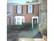 Charming brick townhome featuring a decorative front door and bay window at 8053 Woodlake Dr, Riverdale, GA 30274