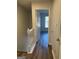 Hallway with wood-look flooring leading to a room with natural light coming from a window at 8053 Woodlake Dr, Riverdale, GA 30274
