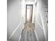 Hallway featuring neutral plank flooring, white trim and neutral walls at 8053 Woodlake Dr, Riverdale, GA 30274