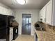 Traditional kitchen featuring granite countertops, tile backsplash, stainless appliances, and white cabinetry at 8053 Woodlake Dr, Riverdale, GA 30274