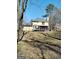 A large backyard with mature trees, a deck, and a covered porch at 230 Mapledale Trl, Sharpsburg, GA 30277