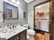 Well-lit bathroom with a vanity, a decorative mirror, and a laundry room with a washer and dryer in the background at 230 Mapledale Trl, Sharpsburg, GA 30277