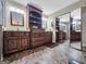 A bathroom with a double sink, built-in shelving, granite countertops and mirrored closet doors at 230 Mapledale Trl, Sharpsburg, GA 30277