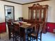 Elegant dining room with a large wooden table, cushioned chairs, a hutch, and a view into the modern kitchen at 230 Mapledale Trl, Sharpsburg, GA 30277