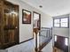 Upstairs hallway with a view to the floor below, wood doors and trim and a bedroom in the background at 230 Mapledale Trl, Sharpsburg, GA 30277