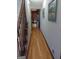 Hallway with hardwood flooring, wooden trim, and artwork, providing a seamless transition between different rooms at 230 Mapledale Trl, Sharpsburg, GA 30277