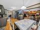 Spacious kitchen with gray cabinets, stainless appliances, tile countertops, and an adjacent dining area with hardwood flooring at 230 Mapledale Trl, Sharpsburg, GA 30277
