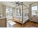 Spacious bedroom featuring a four-poster bed, hardwood floors, large windows, and neutral décor at 132 Platinum Rdg, Sharpsburg, GA 30277
