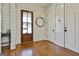 Inviting foyer with hardwood floors, shiplap walls, and a wood-framed glass front door letting in natural light at 132 Platinum Rdg, Sharpsburg, GA 30277