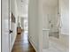 Bright hallway leading to a tiled bathroom with a glass-enclosed shower and soaking tub at 132 Platinum Rdg, Sharpsburg, GA 30277
