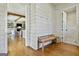 Hallway with a wooden bench, shiplap walls, hardwood floors, and a view into the living area at 132 Platinum Rdg, Sharpsburg, GA 30277