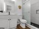 Stylish bathroom featuring a shower with black hardware, white vanity and marbled tile at 321 Pleasant Valley Rd, Mcdonough, GA 30253