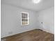 This cozy bedroom features neutral walls, wood-look flooring, and a window at 321 Pleasant Valley Rd, Mcdonough, GA 30253
