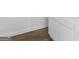 Close-up of flooring featuring a light wood grain pattern with white baseboards and white cabinets in the background at 321 Pleasant Valley Rd, Mcdonough, GA 30253