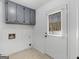 Laundry room with grey cabinets, a window, and a white door at 321 Pleasant Valley Rd, Mcdonough, GA 30253