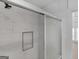 Shower with sliding glass door, built-in shelf and white marble tiling at 321 Pleasant Valley Rd, Mcdonough, GA 30253