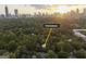 Aerial view of neighborhood location amidst a dense canopy of trees and a nearby downtown city skyline at 870 Monroe Ne Dr, Atlanta, GA 30308