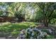 Beautiful backyard featuring a lush lawn, mature trees, hydrangeas, and a wooden fence at 870 Monroe Ne Dr, Atlanta, GA 30308