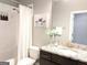 Cozy bathroom featuring marble tile, granite countertop, dark wood cabinets, and tub with shower at 870 Monroe Ne Dr, Atlanta, GA 30308