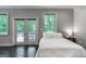 Bright bedroom with hardwood floors, white walls, and double door access at 870 Monroe Ne Dr, Atlanta, GA 30308